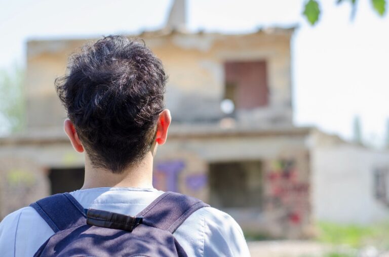 Male asylum seeker looking at a building