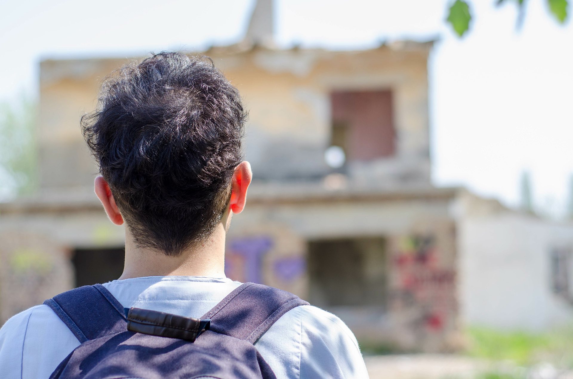 Male asylum seeker looking at a building