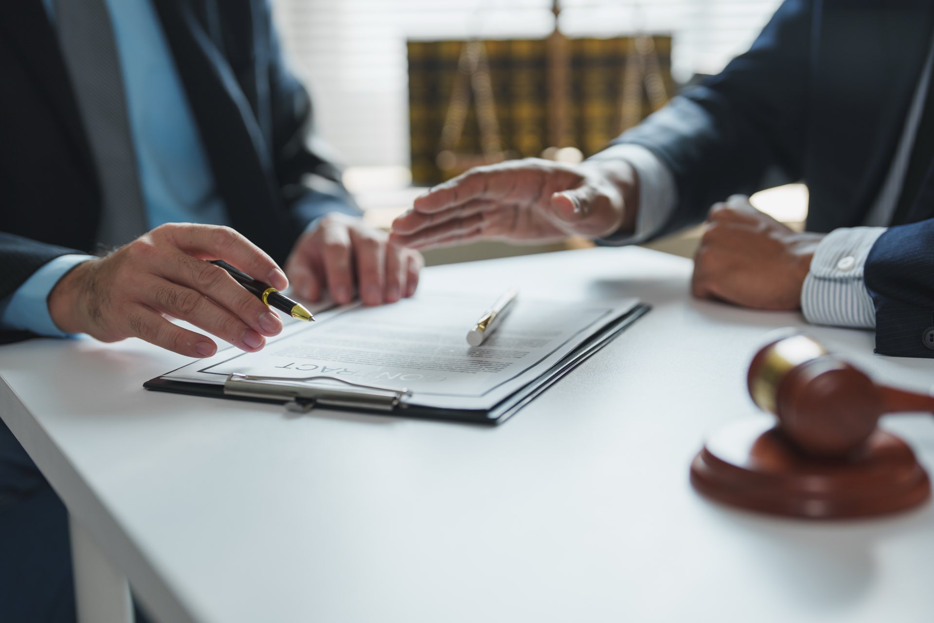 Two people going over paperwork on a clipboard on a desk