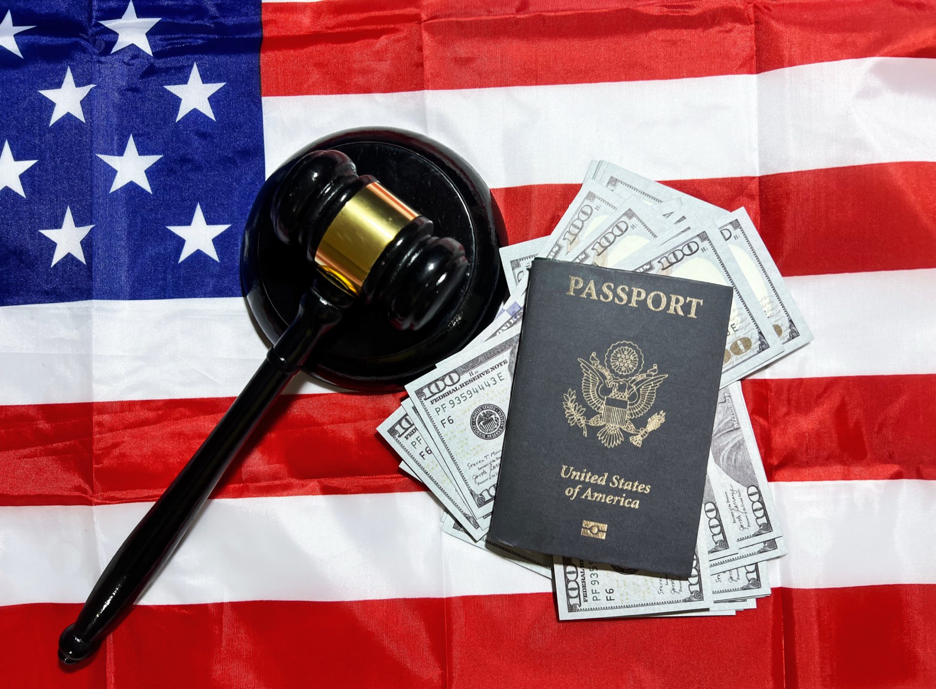 Gavel, money, passport with an American flag backdrop