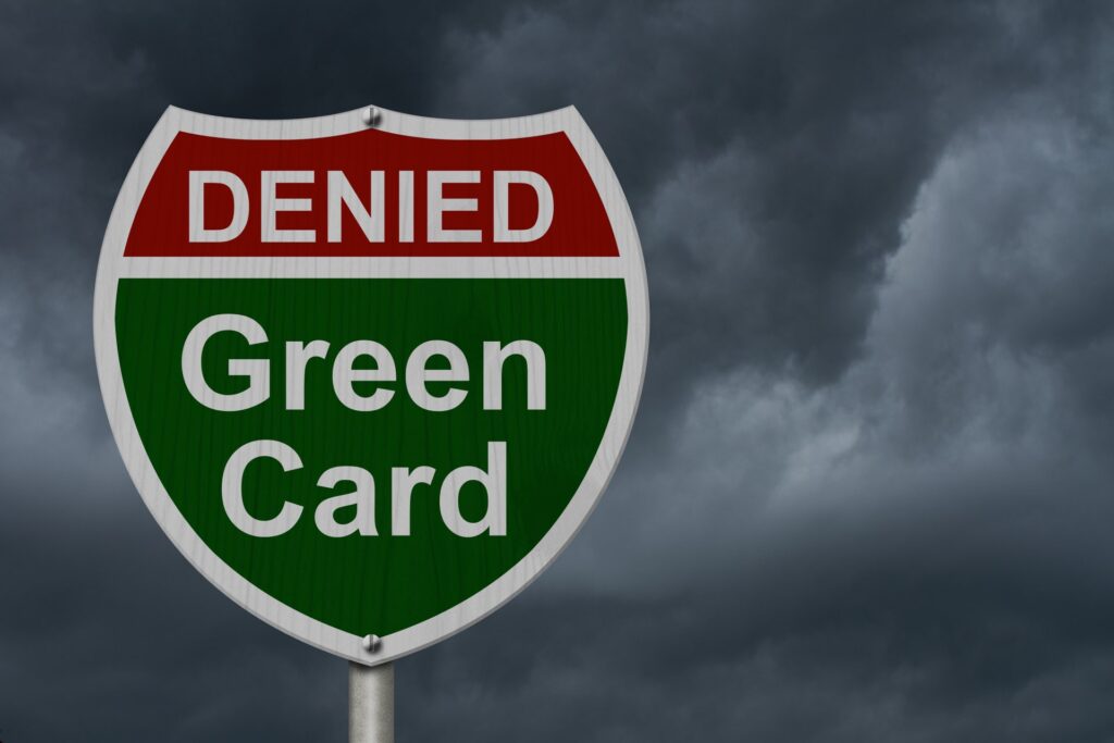 Black sky background with a sign that says denied in red and green card in green