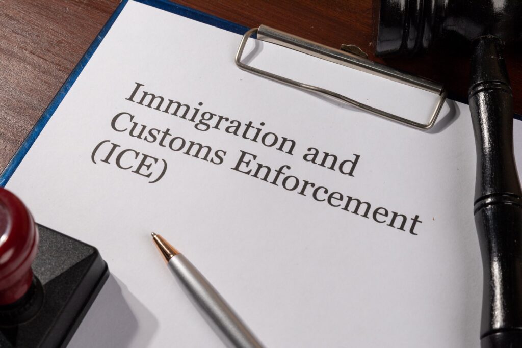 A clipboard that says Immigration Customs Enforcement(ICE) next to a gavel