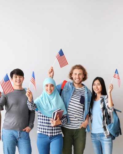 Group of students with USA flags on light background