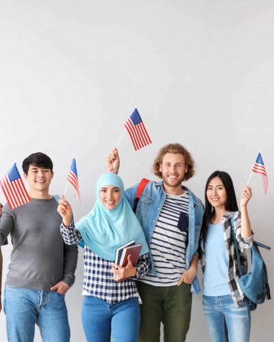 Group of students with USA flags on light background