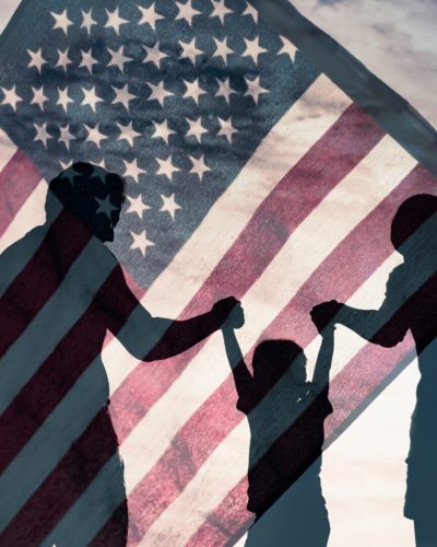 Patriotic man, woman, and child waving American flags in the air.