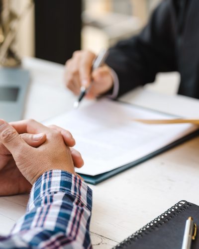 Business people negotiating a contract. Human hands working with documents at desk and signing contract.