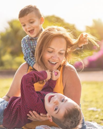 Happy mother having fun with her two sons playing outdoor - Love and family concept - Focus on mother face